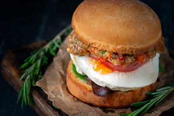 Vegetable homemade Burger made from fried eggplant, tomato, lettuce avocado and mozzarella cheese on a wooden Board.