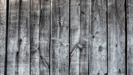 Old wooden wall. Boards with many cracks knots nails and holes