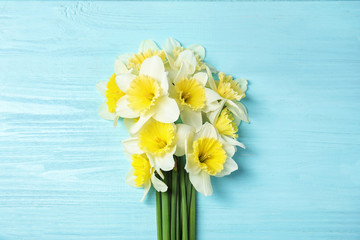 Bouquet of daffodils on wooden background, top view. Fresh spring flowers