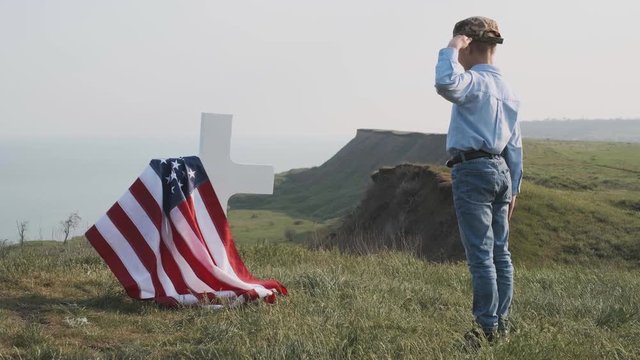 a woman with her son near the grave of her husband an American soldier of the hero of America who died in a hot spot defending the democracy and independence of the United States of America