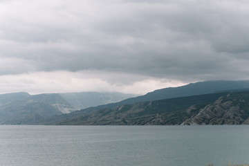 View opening onto the Chirkei reservoir from the shore. Mountains in the background of the cloudy sky. Sulak Canyon, Dagestan