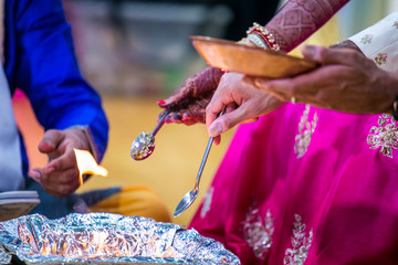 Obraz na płótnie Canvas Indian hindu wedding ceremony ritual items, spoon and hands close up