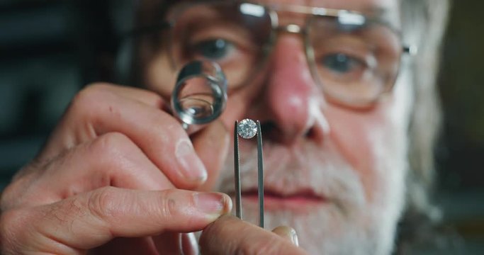 Slow motion macro close up of experienced goldsmith heating a precious metal for making a handmade jewelry in a workshop. Shot in 8K.Concept of jewelry, luxury,goldsmith, gold, silver, precious metals
