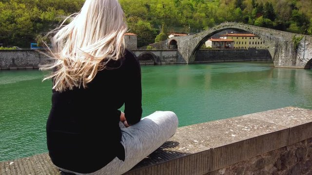 Blond girl contemplates the Bridge of the Devil (Ponte della Maddalena) Garfagnana Lucca