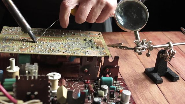 master soldering radio components on the desktop, close-up