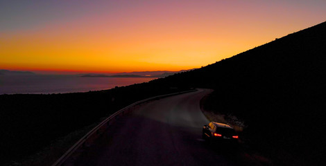 DRONE: Tourist car exploring the untouched island in Greece at early dawn.