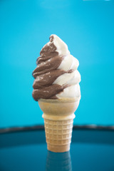 soft serve vanilla and chocolate ice cream in cone on blue background - 264668429