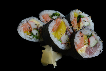 tradicional shushi with salmon, mango and kani in black background