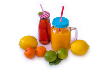 Isolate with fruit and citrus juice in special jars with colored lids and straws for drinking, lemons, limes, tangerines