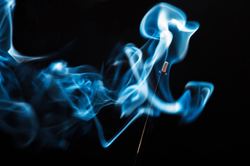 Fototapeta premium blue smoke of incense on black background