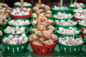 Buckets of red onions and garlic for sale on a Canadian market in Montreal. The culture of these two bulbs are typical from the agriculture of the province of Quebec