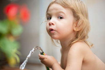 Niña rubia bebe publicidad jugando agua verano