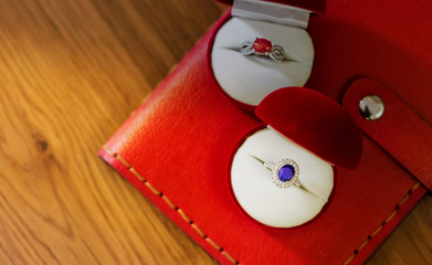 Beautiful blue orange gemstone ring placed in the box Beautiful red book and Lay on the wooden floor