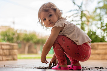 Niña rubia bebe publicidad jugando tierra verano