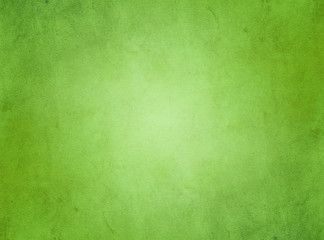 Fototapeta na wymiar An elegant, rich green, grunge parchment texture background with glowing center. 