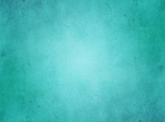 Fototapeta na wymiar An elegant, rich turquoise, grunge parchment texture background with glowing center. 