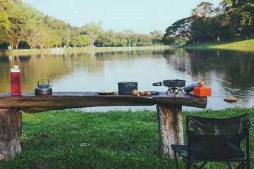 The background of the pot and gas picnic that is placed on the table wooden. Camping, picnic, cooking, eating by the lake.
