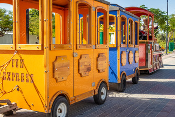 Children's colorful train awaits departure in the amusement park.