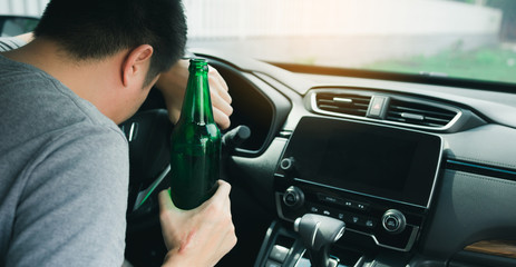 Asian men drink a lot of alcohol until and unconscious his can't drive home and decide to sleep at the steering wheel.