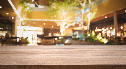 Wood table top (Bar) with blur of night pub or restaurant background/selective focus .For montage product display