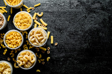 Different types of dry pasta in bowls.