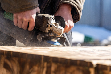 background grinding wood surface grinder with abrasive wheel. worker carpenter grinds the wood...