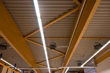Large wooden trusses support the roof of a large factory building