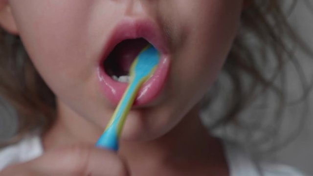 Close-up mouth of little child girl is brushing her teeth with toothbrush. Dental care concept.
