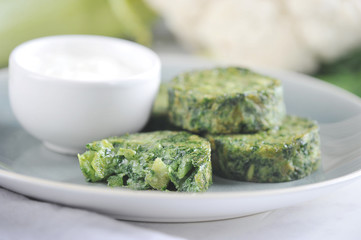 Vegetable patties from shinah, zucchini and cauliflower. Next to the meatballs cup with sauce. The concept of healthy eating. Close-up. Macro shooting.