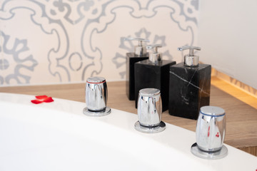close-up of a large white jacuzzi bath decorated with red rose petals