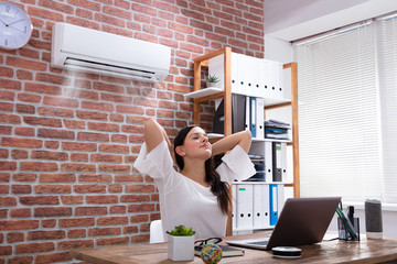Businesswoman Enjoying The Cooling Of Air Conditioner