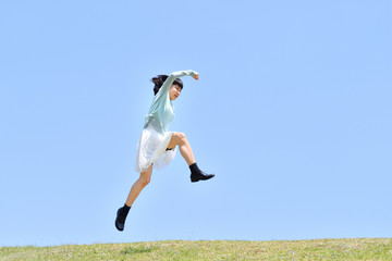 青空でジャンプする女の子