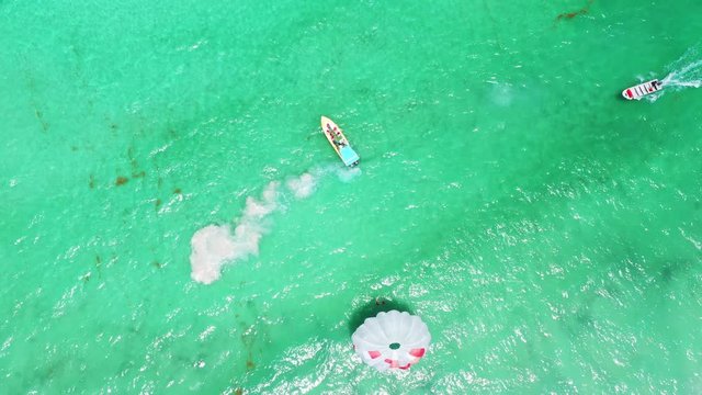 People having fun doing parasailing above Caribbean Sea. Summer holidays. Travel destination