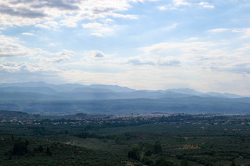 Fototapeta na wymiar Greek landscape view to the valley covered by morning fog with the mountains on the background