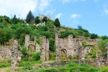 Fototapeta na wymiar Picturesque ruins of abandoned medieval town Mystras, Greece against blue summer sky