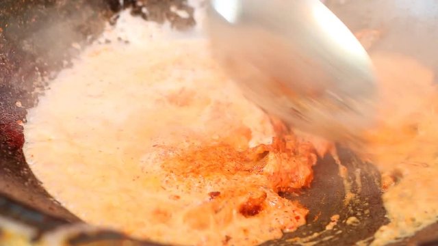  Frying red curry paste with coconut milk in pan to make red curry, Thai famous food
