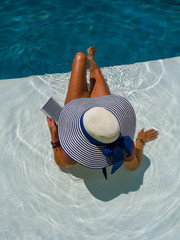 Woman at the swimming pool reading