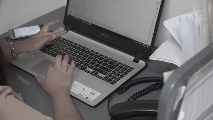 FEMALE EMPLOYEE ON LAPTOP WORKING ON EXCEL SHEET