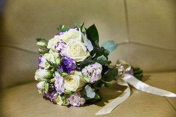 Wedding bouquet with ribbons. Roses, freesia. Beige background.