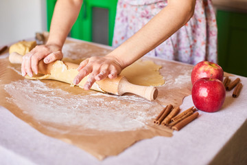Woman kneading dough for the apple pie on kitchen table. Rustic style