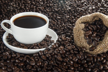 Coffee cup and bag on background of coffee beans.