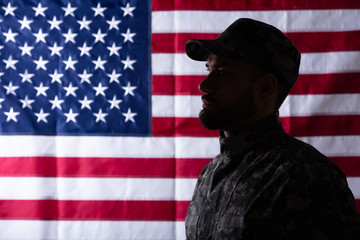 Male Solider Standing In Front Of An Us Flag