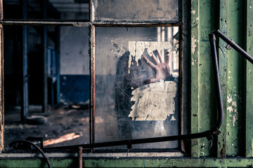 Woman standing behind the window, you can see her hand on the glass.
