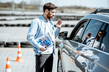 Instructor explaining the route scheme of training for a driver who sits in the learning car on the...
