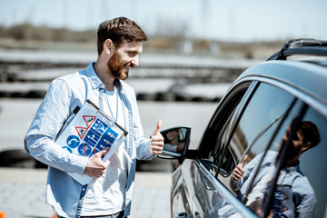 Instructor explaining the route scheme of training for a driver who sits in the learning car on the...