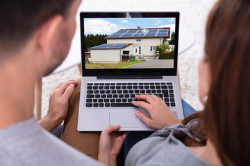 Couple Looking At House On Laptop