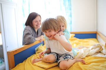children play with their mother on children's bed
