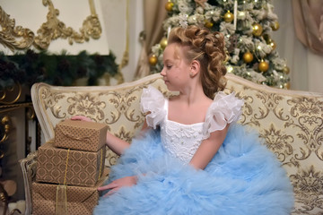 princess in white with blue elegant dress sits on an armchair
