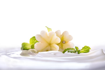 Plain yogurt with fresh flower shape apple on top in bowl isolated on white background