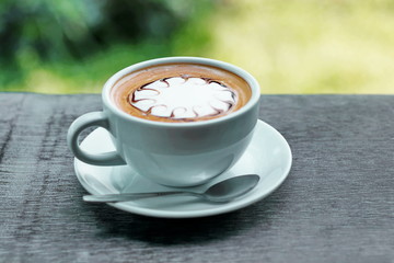 Cup of hot coffee latte on a wooden table natural beauty.